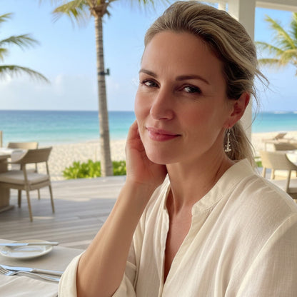 Woman wearing Big Blue by Roland St John sterling silver hammerhead shark earrings at a beachside restaurant.