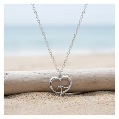 Big Blue by Roland St John sterling silver mini necklace with a heart pendant featuring an ocean wave design. Beach setting.