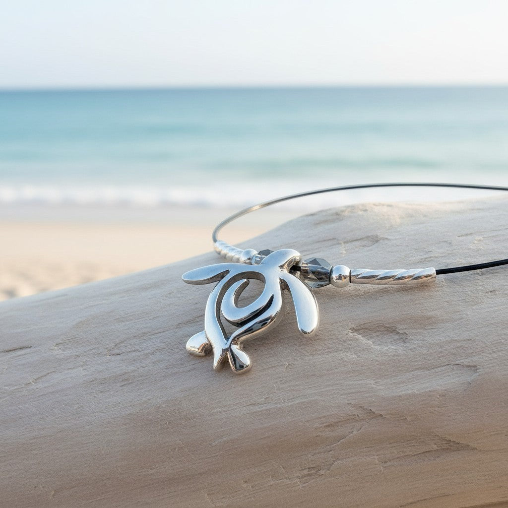 Big Blue by Roland St John sterling silver choker necklace with a mini sea turtle pendant, set against a beach and ocean backdrop.