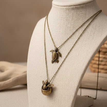 Big Blue by Roland St John layered bronze necklace with two sea turtle pendants, one sculpted and one hatching from an egg.