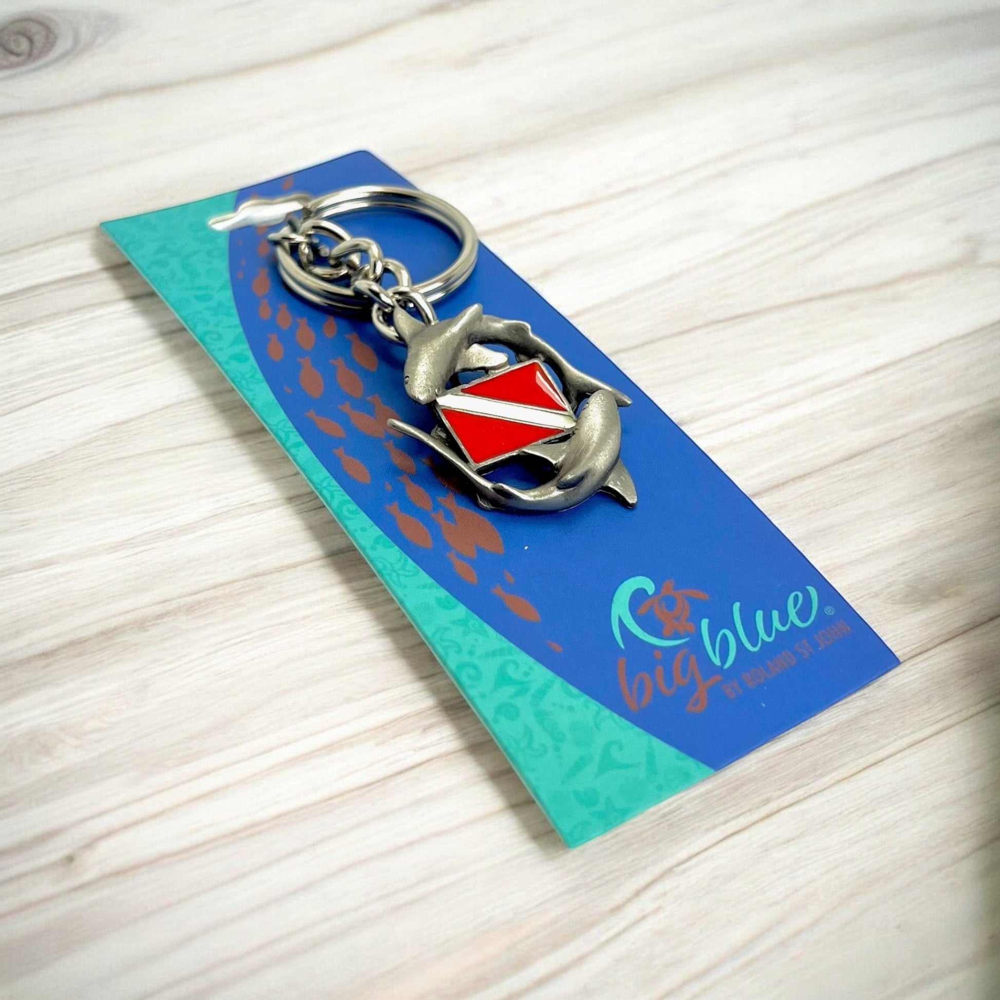 Big Blue by Roland St John pewter keychain with two sharks circling a red and white dive flag.