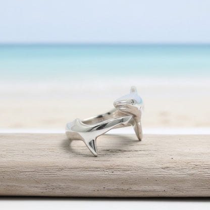 Big Blue by Roland St John sterling silver adjustable shark ring with realistic detail, set against a beach and ocean backdrop.