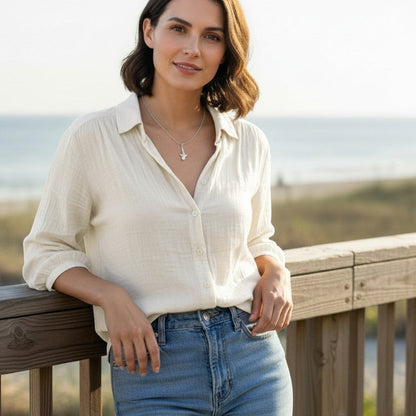 Big Blue by Roland St John sterling silver mini whale shark necklace on a woman wearing a cream blouse and jeans.