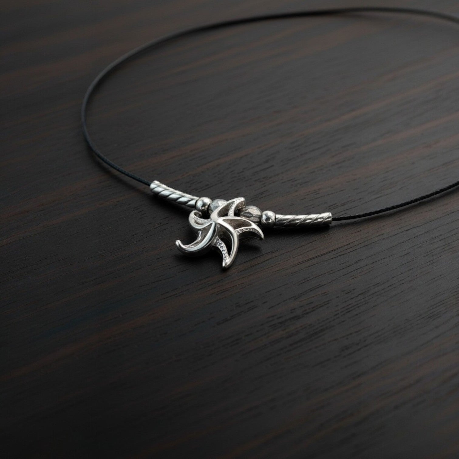 Big Blue by Roland St John sterling silver choker necklace with a miniature 3D starfish pendant, featuring a black cord and silver accents.
