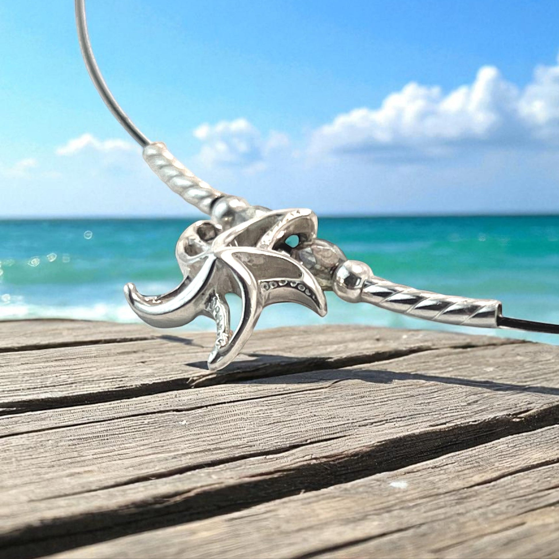 Big Blue by Roland St John sterling silver choker necklace with a detailed 3D starfish pendant, set against a beach and ocean backdrop.