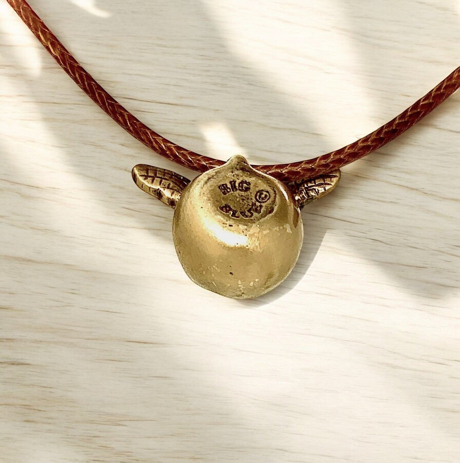 Big Blue by Roland St John bronze baby sea turtle pendant on a braided brown cord. Realistic hatchling design.
