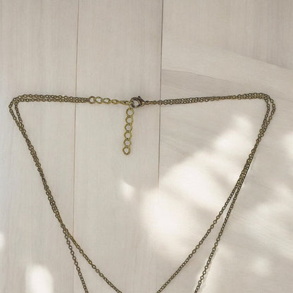 Big Blue by Roland St John layered bronze shark pendant necklace with topaz bead and adjustable clasp.