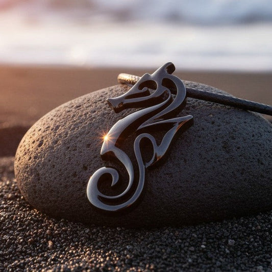 Big Blue by Roland St John 'Polo' seahorse pendant necklace in jet black finish, on a rock by the sea.