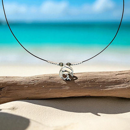 Big Blue by Roland St John sterling silver choker necklace with a miniature dolphin pendant, set on a black cord with two small grey beads.