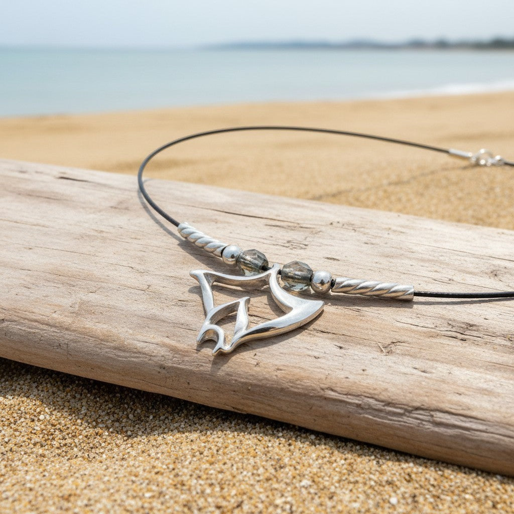 Big Blue by Roland St John sterling silver manta ray choker necklace with grey beads on a beach.