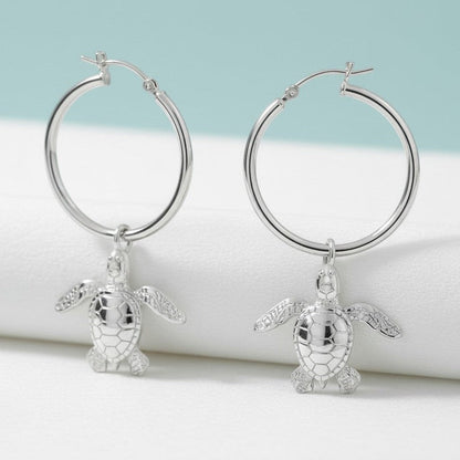 Big Blue by Roland St John sterling silver hoop earrings with dangling baby sea turtle charms. Detailed, realistic design.
