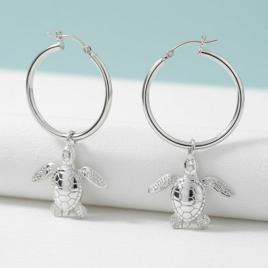 Big Blue by Roland St John sterling silver hoop earrings with dangling baby sea turtle charms. Detailed, realistic design.