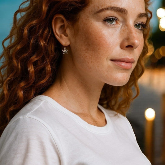 Big Blue by Roland St John bronze starfish drop earrings on a model with red curly hair.