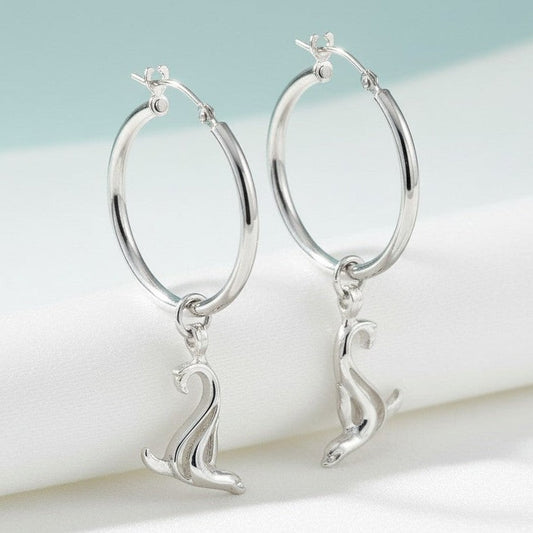 Big Blue by Roland St John sterling silver hoop earrings with dangling sea lion charms.