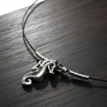 Big Blue by Roland St John sterling silver choker necklace with a miniature seahorse pendant, worn close to the neckline.